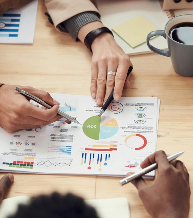 Colleagues discussing data and strategy in an office meeting.