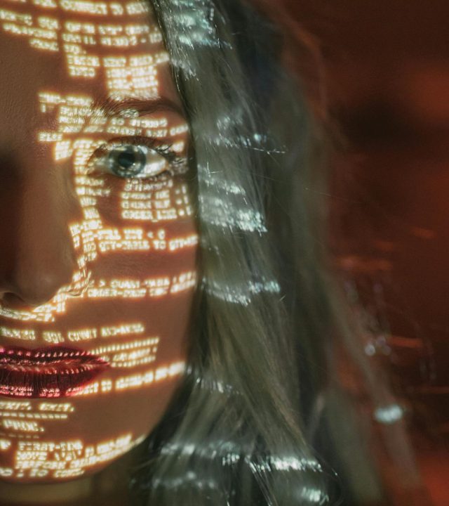 Abstract cyberpunk portrait with code projected on a woman's half face, symbolizing technology integration.